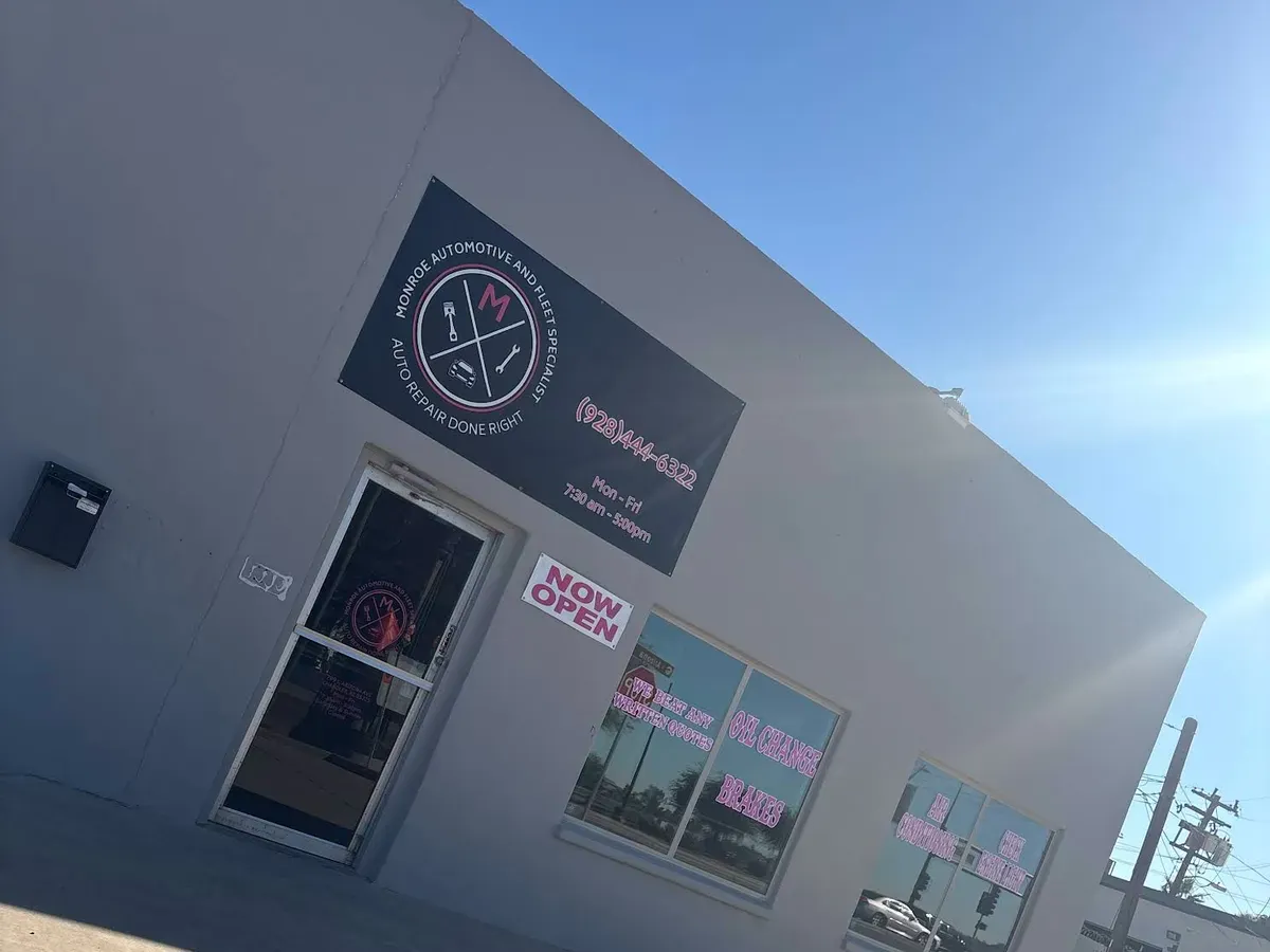 Monroe Automotive and Fleet Specialist sign above the shop entrance and Now Open banner